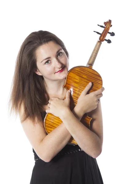 Brunette stands and holds violin in studio against white backgro — 스톡 사진
