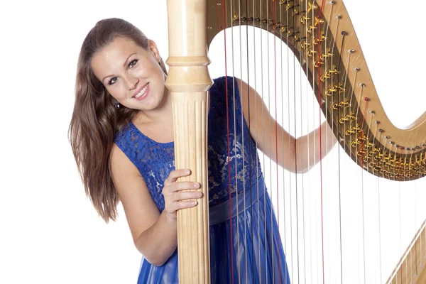 Young caucasian woman with concert harp in studio against white — Stock Fotó