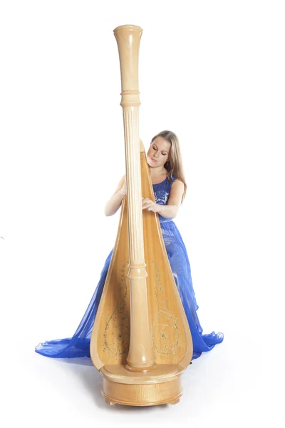 Young caucasian woman sits and plays concert harp in studio agai — 스톡 사진