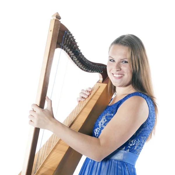 Young caucasian woman stands with small harp in studio against w — Stock Fotó