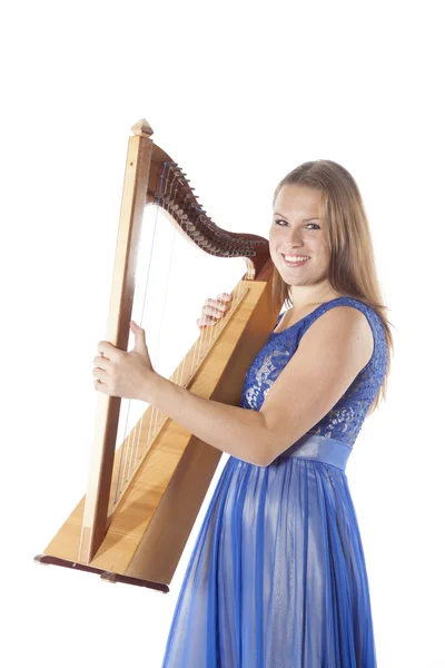 Young caucasian woman stands with small harp in studio against w — ストック写真