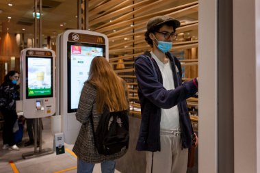 Maskeli adamlar McDonald 's' da elektronik vitrin siparişi veriyor. Koronavirüs salgını. Moskova, Rusya, 19 / 10 / 2020.