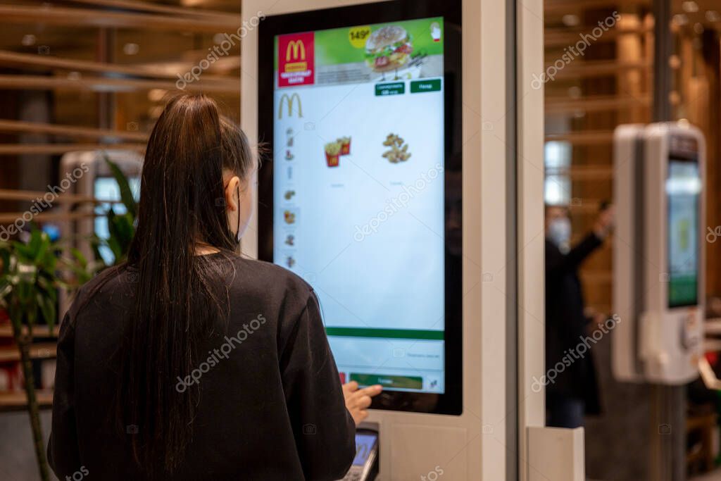 The girl makes an order on the electronic display at McDonald's. Moscow, Russia, 19/10/2020.