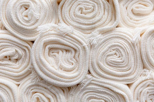 Soft white terry towels in rolls. Spa and body treatments. Background. Space for text.