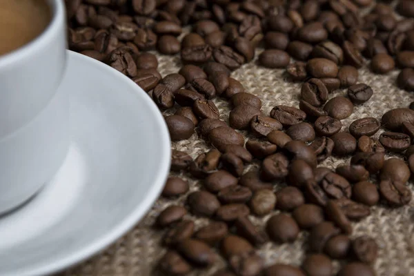 Chicchi Caffè Tostati Sparsi Una Tazza Bianca Con Una Bevanda — Foto Stock