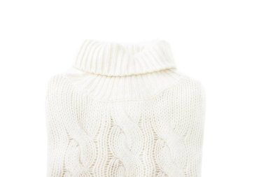 İzole edilmiş beyaz arka planda örülmüş yün beyaz süveter. Yakın plan..