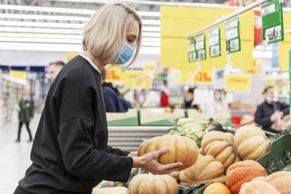 Молодая Блондинка Медицинской Маске Выбирает Тыкву Овощной Секции Супермаркета Пандемия — стоковое фото