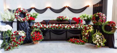 The coffin is decorated with various flowers. A beautiful funeral ceremony. Panorama format. clipart