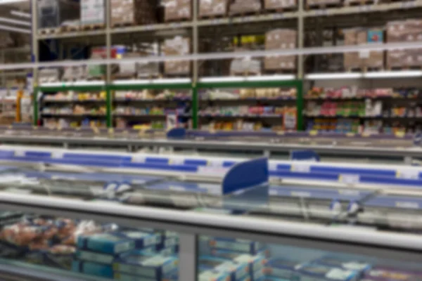 Interior of a large light supermarket. Blurred.