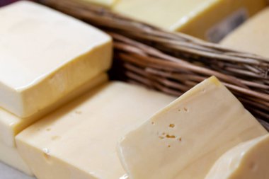 Dükkandaki tezgahta dilimlenmiş peynir parçaları. Yakın plan. Seçici odak.