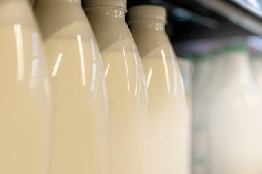 Dükkanda içinde süt olan plastik şişeler. Yakın plan. Yan görünüm.