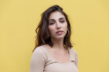 Sarı bir binanın arka planında gülümseyen esmer kadın. Yaşam biçimi.