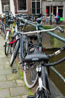 Amsterdam 'da kanala bisikletleri park etmiş. Dikey.