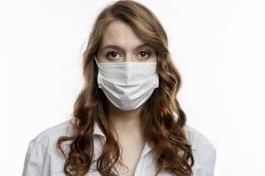 Tıbbi maskeli, ciddi bir genç kadın. Koronavirüs salgını sırasında karantina. Beyaz arkaplan.