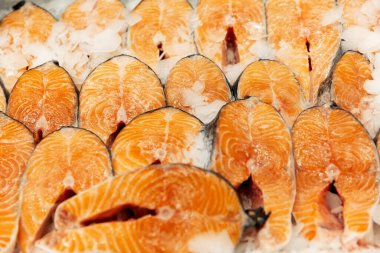 Mağazadaki tezgahta buzlu çiğ balık bifteği. Yakın plan.