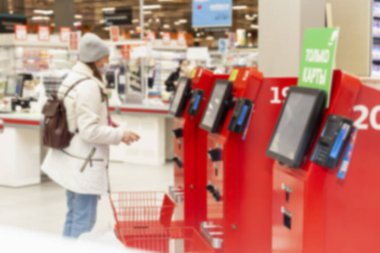 Süpermarketteki kasiyerlerde maskeli müşteriler. Yeni dijital dünya. Bulanık. Moskova, Rusya, 03-31-2021.