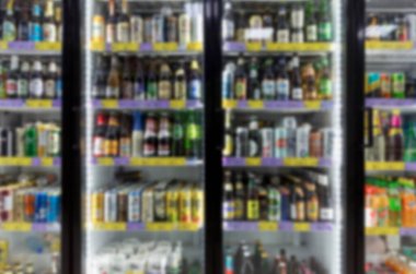 Markette alkollü içeceklerle donatılmış cam vitrinler. Bulanık. Ön görünüm.