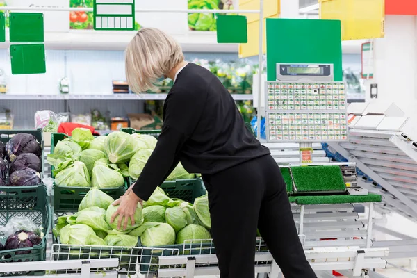 Uma Mulher Seção Supermercado Loja Escolhe Repolho Visão Traseira — Fotografia de Stock