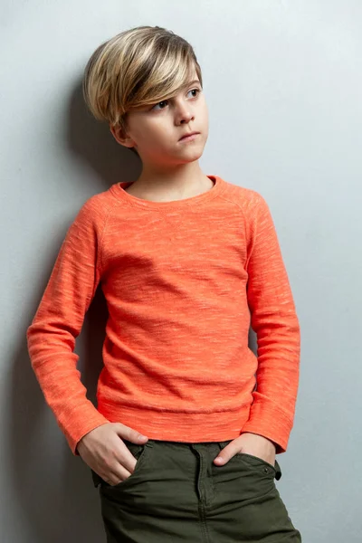 Serious Boy Years Old Orange Jacket Stands Wall Hands Pockets — Stock Photo, Image