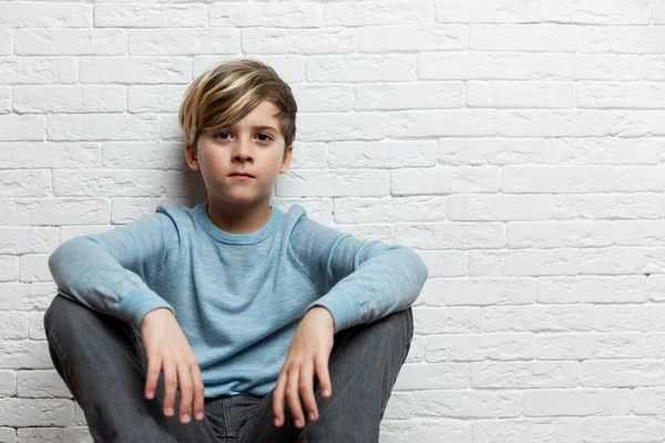 Niño Años Sienta Sobre Fondo Una Pared Ladrillo Blanco Espacio — Foto de Stock