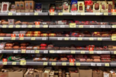 Süpermarketteki raflarda çeşitli sosis lezzetleri var. Bulanık. Ön görünüm.