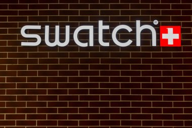 Swatch clock logo on a brick wall. Front view. Moscow, Russia, 07-21-2021.
