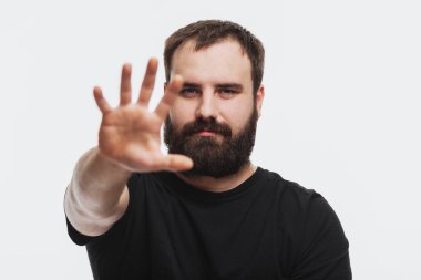 Eli önde uzanmış sakallı genç bir adam. Hiç iz yok. Beyaz arkaplan.