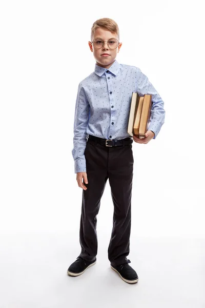 少年は本を手に眼鏡をかけている 青いシャツとズボンの中で9 10歳の子供 教育と研究 高さは 白地だ — ストック写真