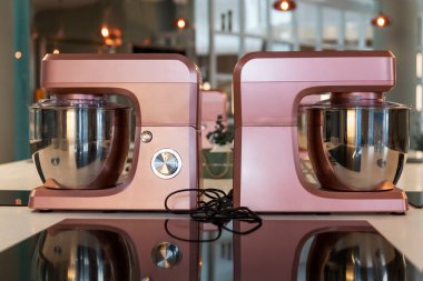 Mutfaktaki aynalı masada kaseli şık mikserler. Mutfakta gerekli yardımcılar var..