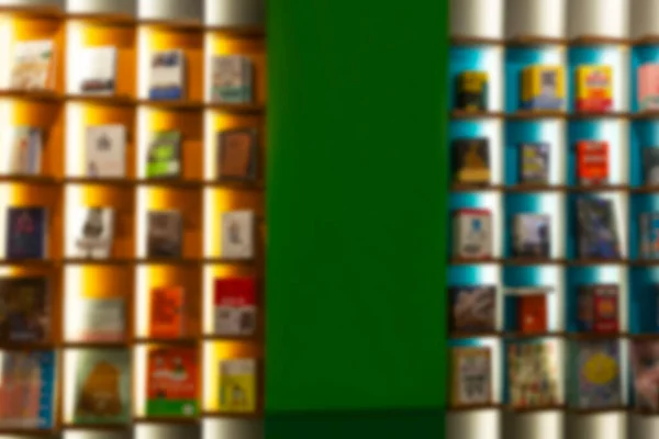 Beautiful multi-colored bookcase with books. Front view. Blurred.