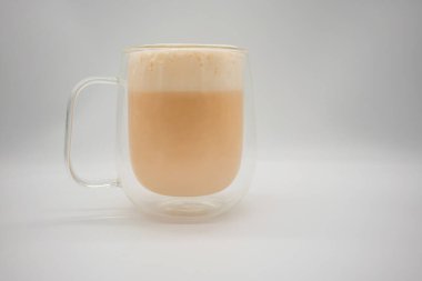 Sütlü köpüklü sıcak Tayland sütlü çayı beyaz arka planda izole edilmiş çift katlı duvar bardağı süsleme için kakao gücü..