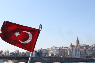 Arka planda Türkiye bayrağı ve İstanbul Şehri manzarası.