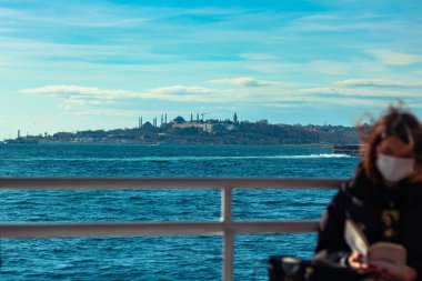 İstanbul manzaralı teknede kitap okuyan bir kadın.