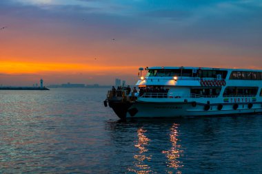 Gün batımında Kadıköy 'de bir feribotun güvertesinde insanlar.