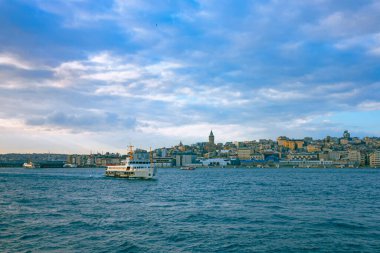 İstanbul şehir manzarası ve gün batımında bir feribot. İstanbul arka plan fotoğrafı. İstanbul feribot hattı arka planda. İstanbul Boğazı ve İstanbul.