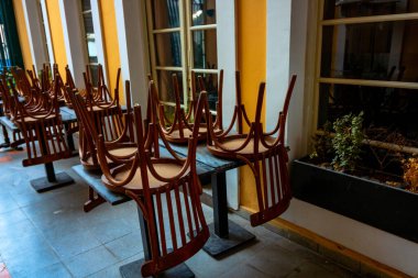 Sandalyeler masanın üstüne yığıldı. Coronavirus salgını önlem ve kısıtlamaları. 