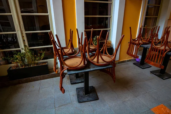 Covid-19 salgın önlemleri nedeniyle sandalyeler masaya yığıldı. Kapalı restoran arkaplan fotoğrafı. 