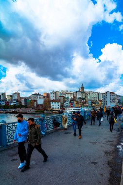 İstanbul 'daki Galata Köprüsü' nde maskeli insanlar yürüyor