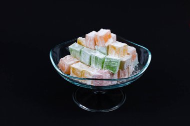 Siyah arka planda izole edilmiş cam bir kasede Türk Lokumu