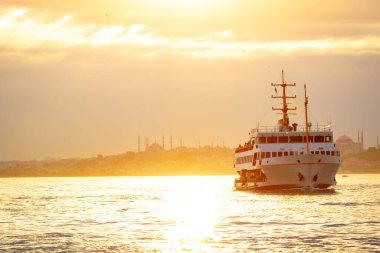 İstanbul gün batımında feribot ve şehir içi İstanbul manzarası. İstanbul 'da toplu taşıma. Türkiye 'ye git. Boğaz üzerinde altın saat ve feribot.