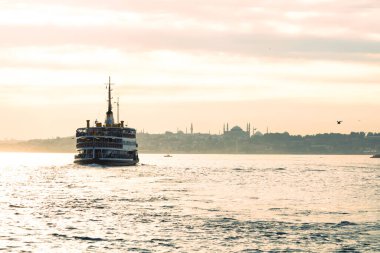 İstanbul gün batımında feribot ve şehir içi İstanbul manzarası. İstanbul 'da toplu taşıma. Türkiye 'ye git. Boğaz üzerinde altın saat ve feribot.