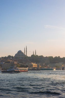 İstanbul arka planı. Süleyman Camii ve gün batımında feribot. İstanbul Türkiye - 5.23.2025
