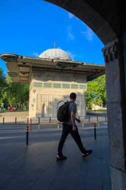 İstanbul 'u ziyaret et. Tophane Çeşmesi 'nin önünde yürüyen bir adam. İstanbul Türkiye - 5.23.2025