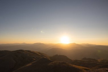 Dağ sırasının üzerinde gün batımı. Nemrut Dağı 'ndan gün batımı görünümü açık gökyüzü ile.