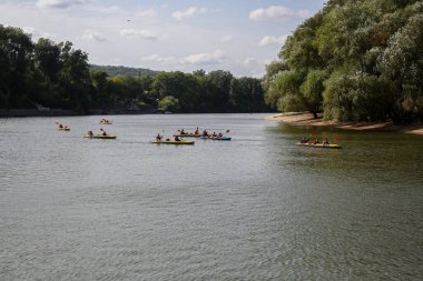 Bir grup kayakçı nehir boyunca yüzer. Yatay çerçeveli çekim.