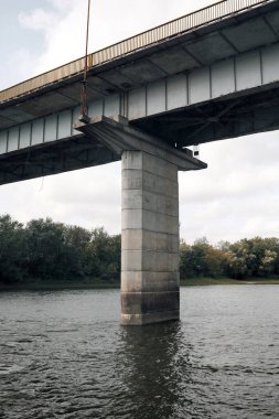 Nehir manzarası ve köprünün altındaki yapılar. Dikey çerçevelenmiş çekim.