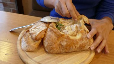 Kadın bir parça pide koparıp restorandaki Pita 'da mantar çorbası içiyor. 4K 2160p 25fps Apple ProRes 422 LT video.