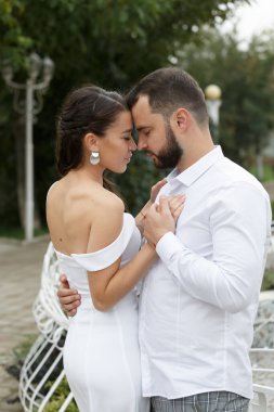 Tarz sahibi çift nazikçe sarılıyor. Mutlu şehvetli düğün çifti kucaklaşması. Yeni evlilerin romantik anları. Dikey çerçevelenmiş çekim.