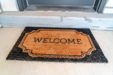 Kapı eşiğinde paspas ve gri ön kapılı ev girişi.