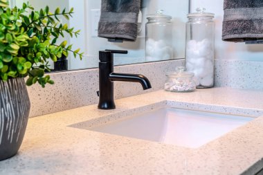 Tek seramik lavabo ve siyah musluk evin içindeki tuvalette.